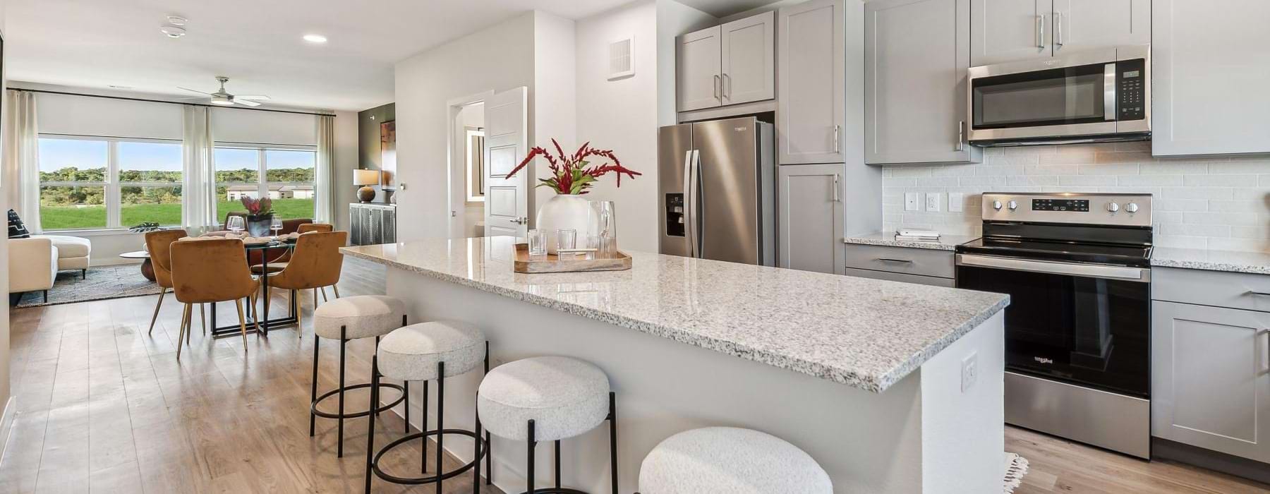 a kitchen with a bar stools and a table