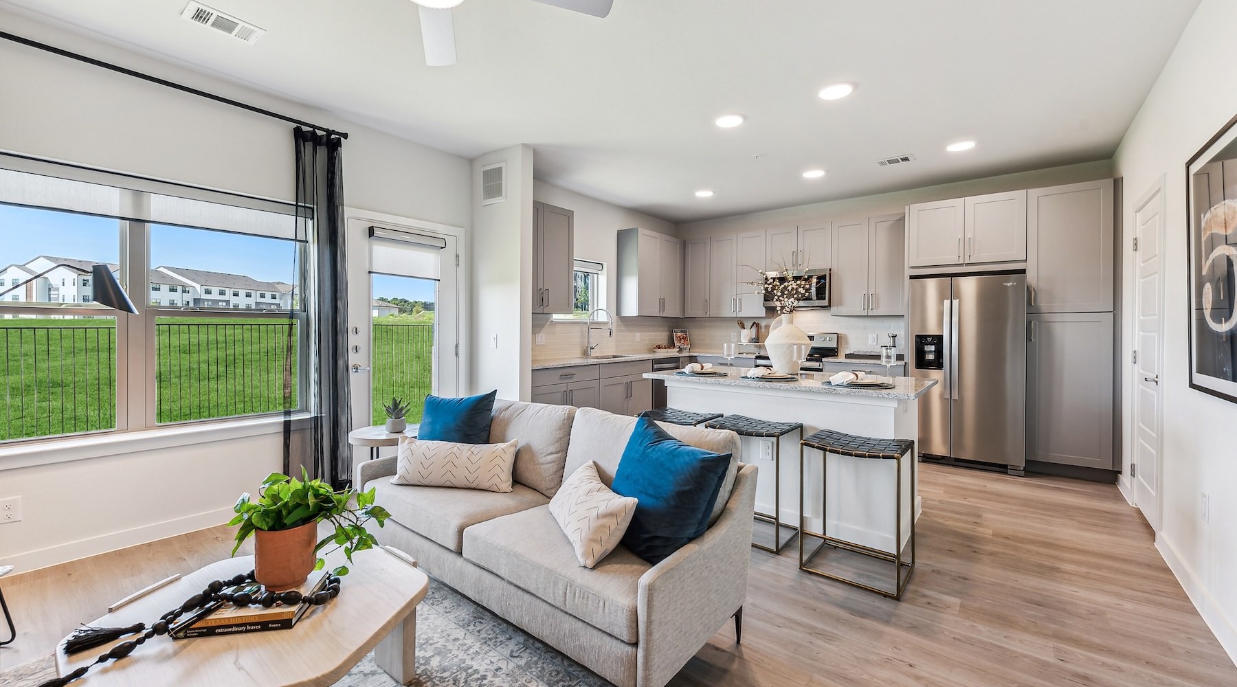 a living room and a large kitchen with a large window