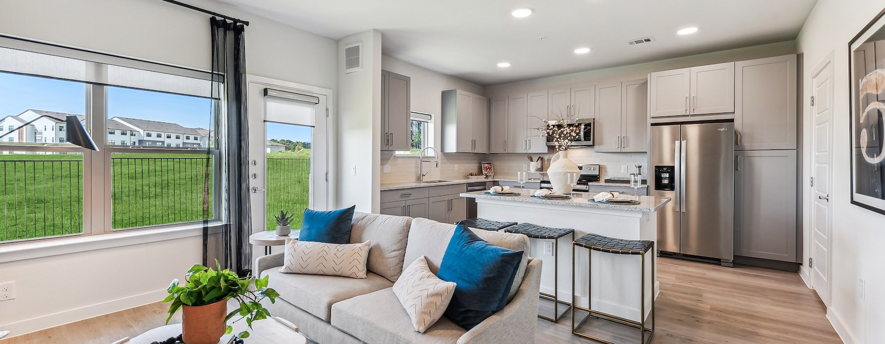 a living room and a large kitchen with a large window