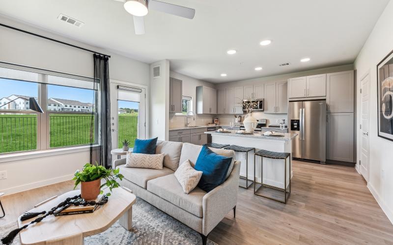 a living room and a large kitchen with a large window